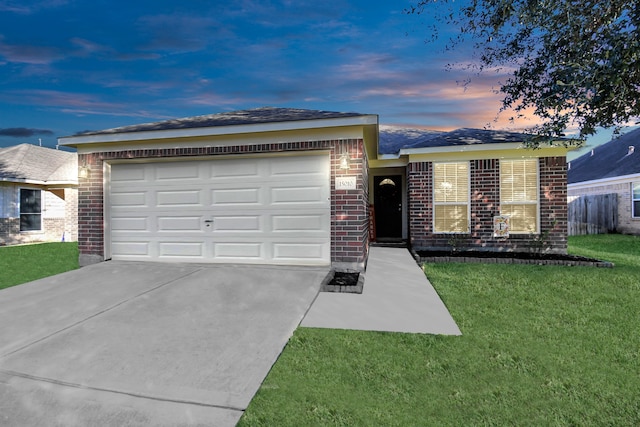 ranch-style house featuring a lawn and a garage