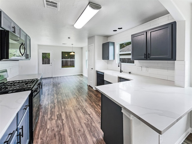 kitchen with black appliances, tasteful backsplash, dark hardwood / wood-style flooring, light stone countertops, and sink