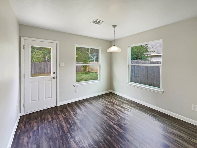 unfurnished dining area with dark wood-type flooring