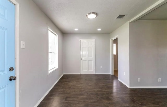 foyer featuring dark wood-type flooring and a textured ceiling