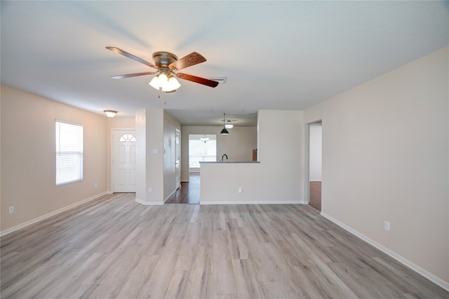 unfurnished living room featuring light hardwood / wood-style flooring and ceiling fan