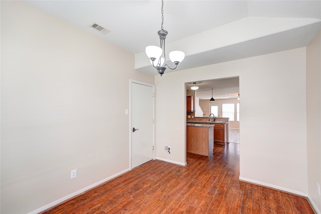 spare room featuring dark hardwood / wood-style flooring, sink, and a notable chandelier