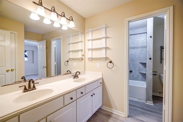 full bathroom featuring toilet, vanity, tiled shower / bath, and hardwood / wood-style floors