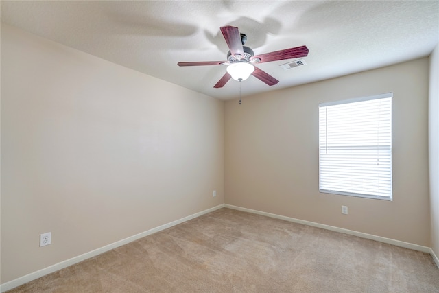 unfurnished room featuring a textured ceiling, light carpet, and ceiling fan