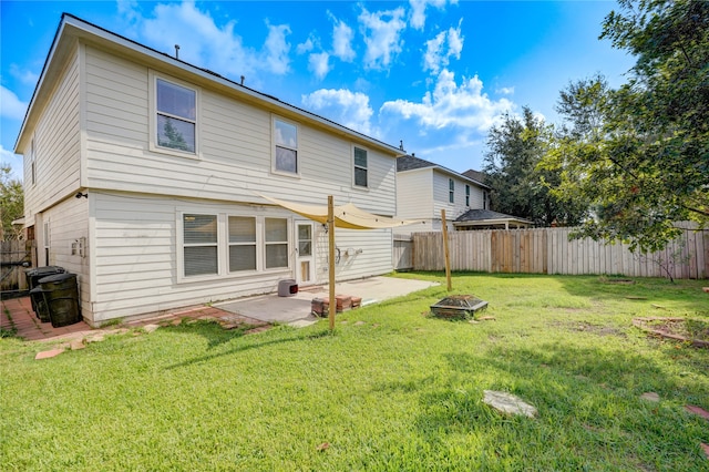 back of property featuring a yard, a fire pit, and a patio area