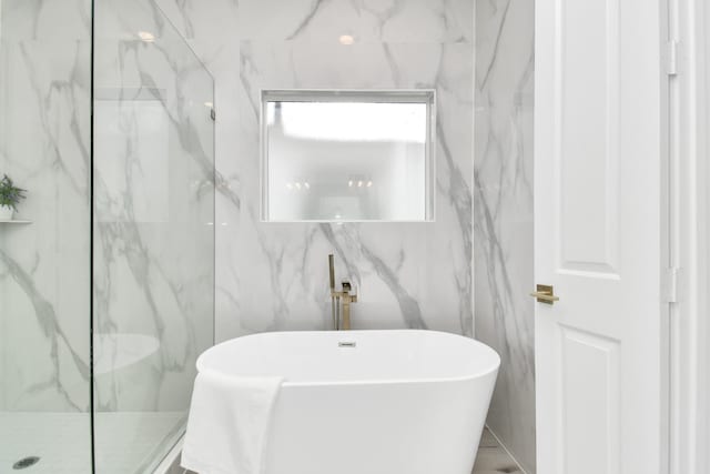 bathroom featuring tile walls and separate shower and tub