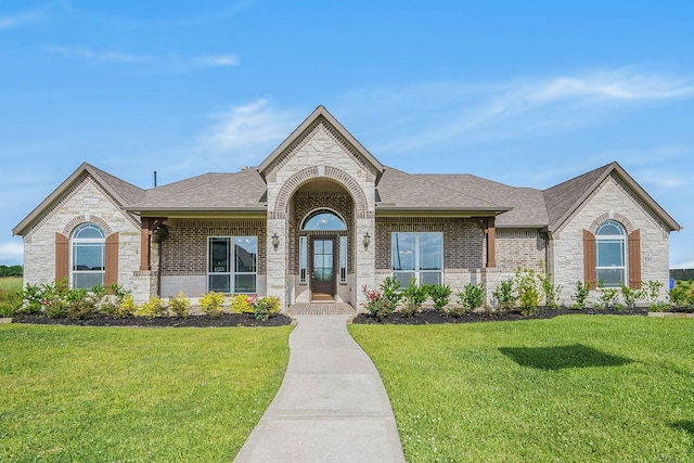 french country inspired facade featuring a front yard