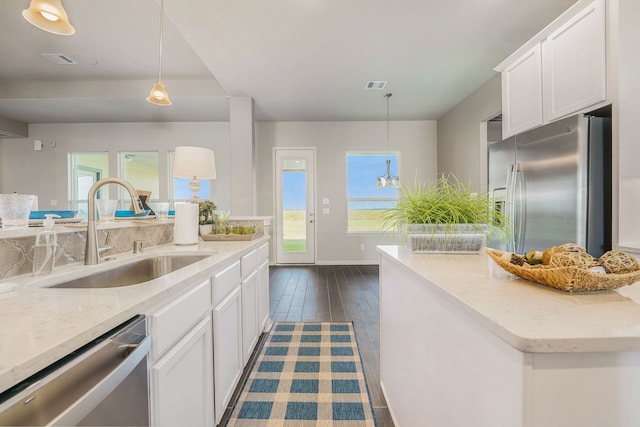 kitchen with appliances with stainless steel finishes, dark hardwood / wood-style flooring, sink, a healthy amount of sunlight, and white cabinets