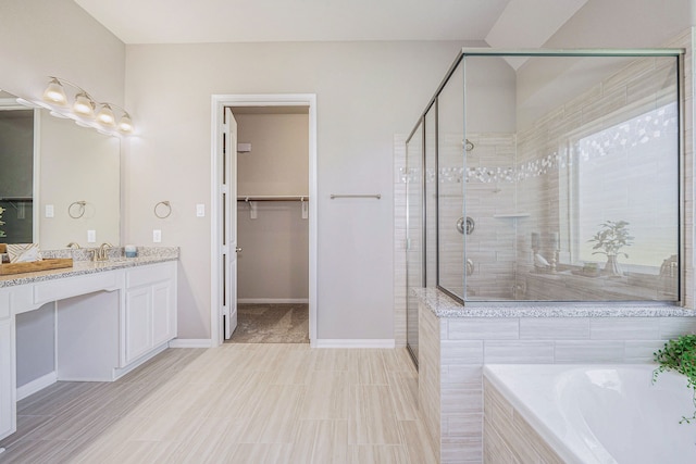 bathroom featuring vanity, plus walk in shower, and wood-type flooring