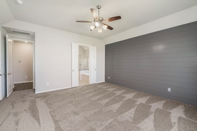 unfurnished bedroom featuring ensuite bathroom, ceiling fan, carpet flooring, and lofted ceiling