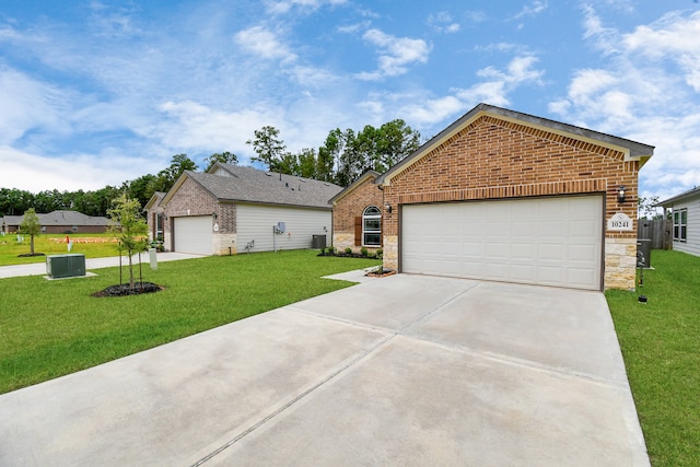 view of front of home featuring a front yard, central AC, and a garage