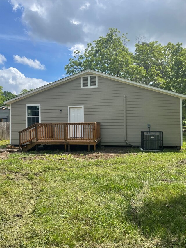 rear view of house with a deck and a yard