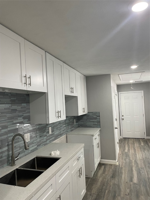 kitchen with white cabinets, sink, dark hardwood / wood-style flooring, and tasteful backsplash