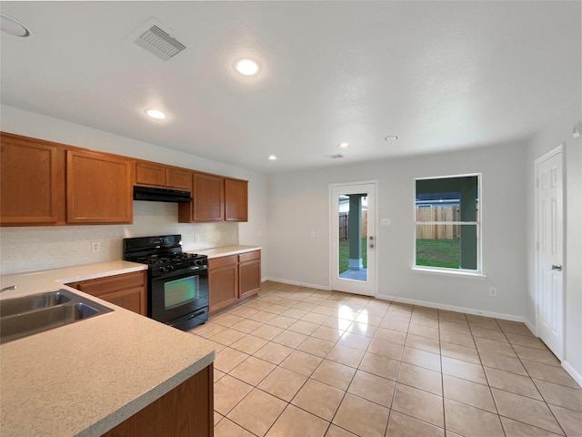 kitchen featuring light tile patterned floors, sink, and black gas range