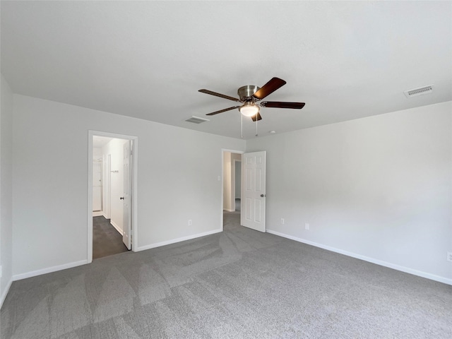 spare room featuring ceiling fan and dark carpet