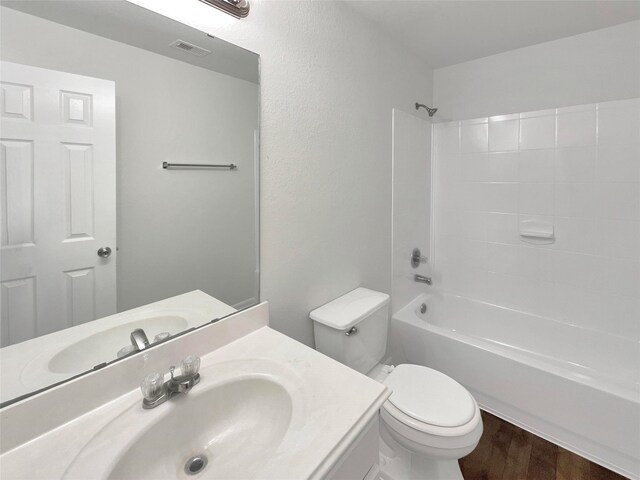 full bathroom featuring toilet, vanity, shower / bathtub combination, and hardwood / wood-style floors