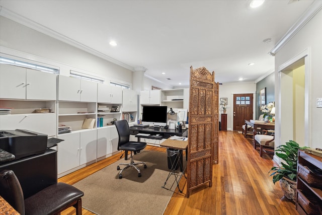 home office with ornamental molding and light hardwood / wood-style floors