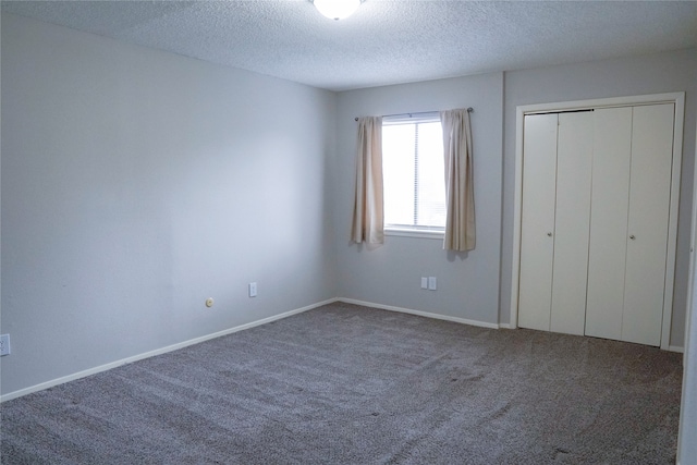 unfurnished bedroom featuring carpet flooring, a closet, and a textured ceiling