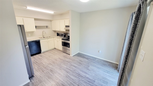 kitchen with white cabinetry, sink, light hardwood / wood-style flooring, a textured ceiling, and appliances with stainless steel finishes