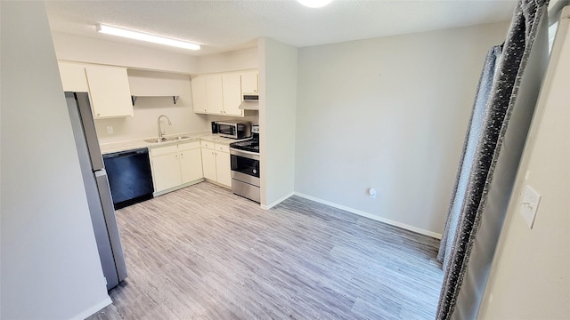 12004B Mighty Oak Dr, Houston, TX 77066 - kitchen with a sink, baseboards, light wood-style floors, and stainless steel appliances