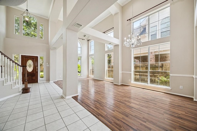 foyer featuring a wealth of natural light, a towering ceiling, and light wood-type flooring