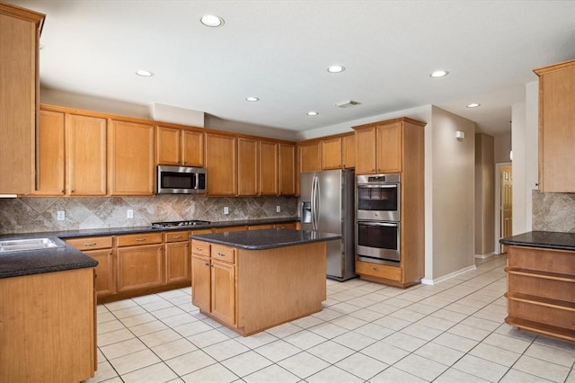 kitchen with a kitchen island, sink, backsplash, and appliances with stainless steel finishes