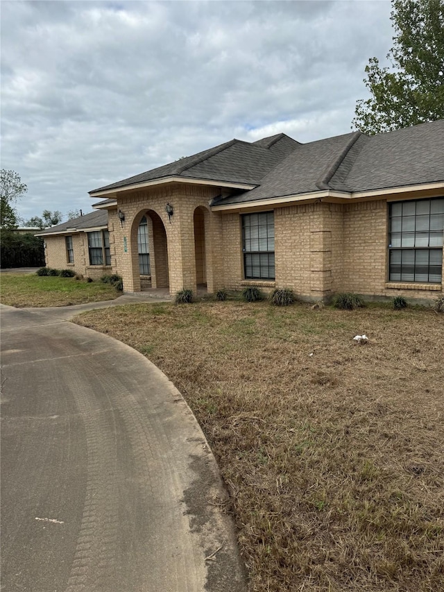617 County Road 99, Alvin, TX 77511 - view of front of property with brick siding, a shingled roof, and a front lawn