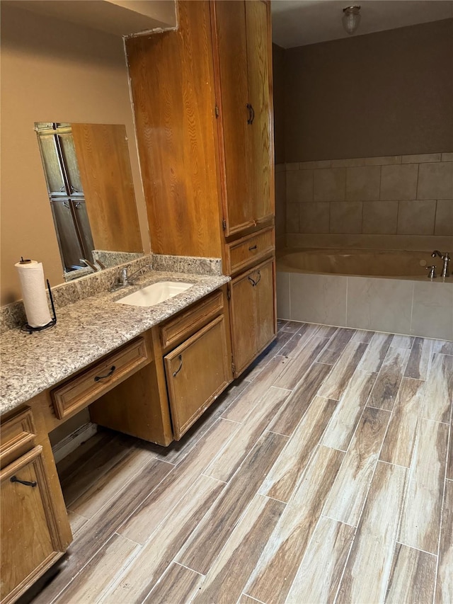 bathroom with a bath, wood-type flooring, and vanity