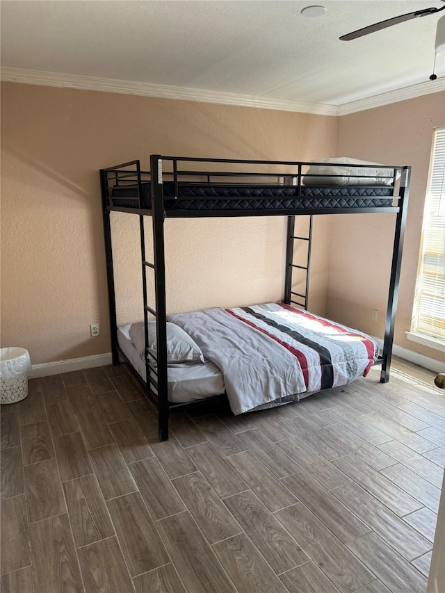 bedroom featuring hardwood / wood-style floors, ceiling fan, and crown molding