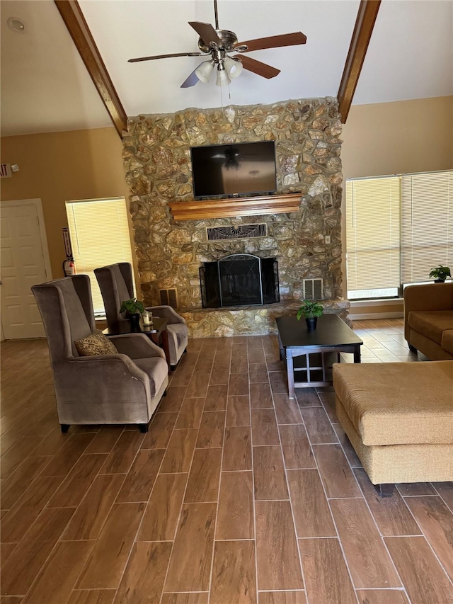 living room featuring vaulted ceiling with beams, ceiling fan, and a fireplace