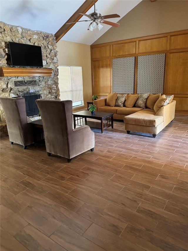 living room with wood walls, dark wood-type flooring, ceiling fan, a fireplace, and beam ceiling