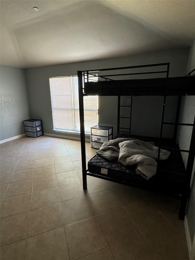 tiled bedroom featuring lofted ceiling