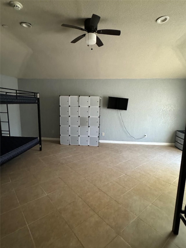 bonus room with a textured ceiling, ceiling fan, tile patterned floors, and lofted ceiling