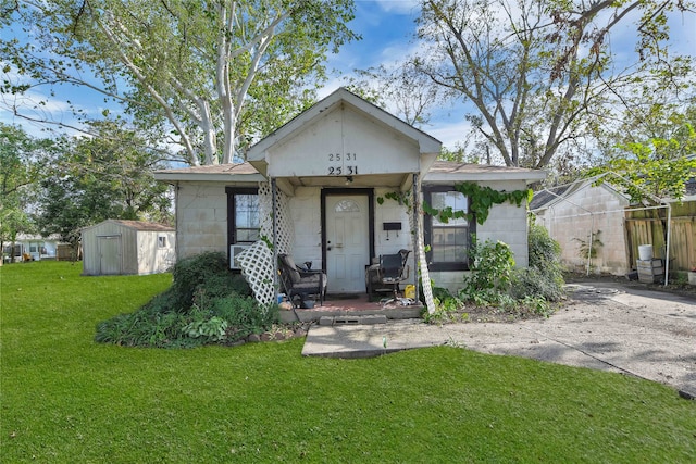 view of front of property featuring a front yard and a storage unit