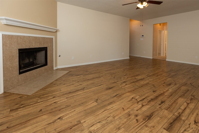 unfurnished living room with a fireplace, ceiling fan, and wood-type flooring