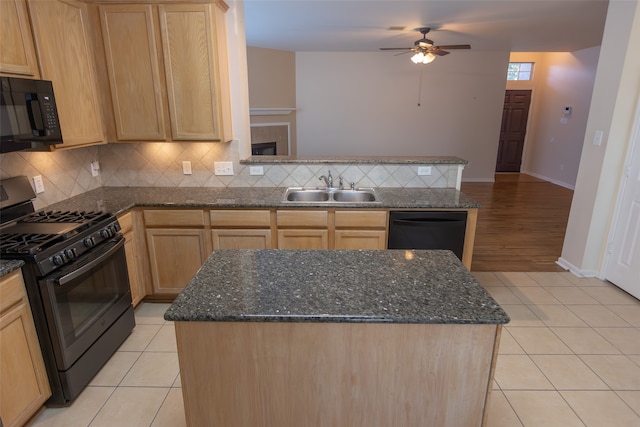 kitchen with sink, dark stone countertops, light tile patterned floors, tasteful backsplash, and black appliances