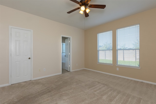 carpeted spare room featuring ceiling fan