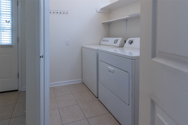 laundry area featuring washing machine and dryer and light tile patterned floors