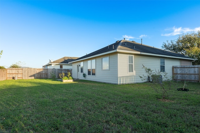 rear view of property featuring a lawn