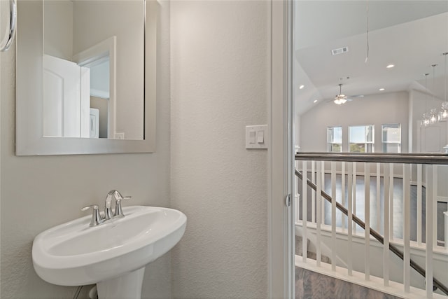 bathroom with hardwood / wood-style floors, lofted ceiling, sink, and ceiling fan with notable chandelier