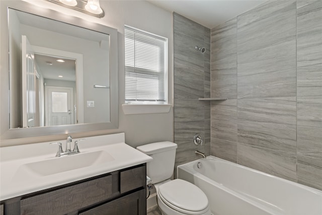 full bathroom with vanity, tiled shower / bath combo, and toilet