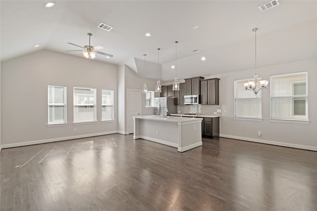 kitchen featuring a wealth of natural light, dark hardwood / wood-style floors, a kitchen island with sink, and appliances with stainless steel finishes