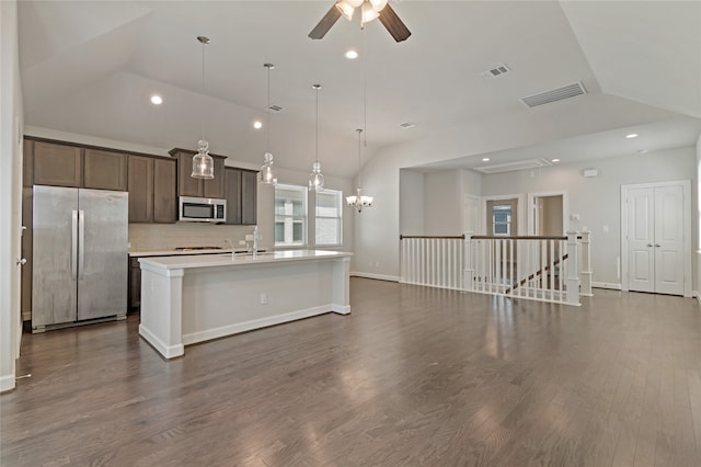 kitchen with a kitchen island with sink, stainless steel appliances, dark wood-type flooring, and vaulted ceiling