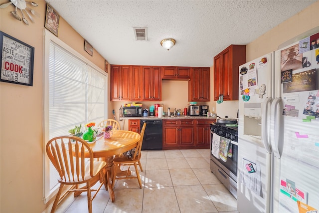 kitchen featuring a textured ceiling, light tile patterned floors, and black appliances