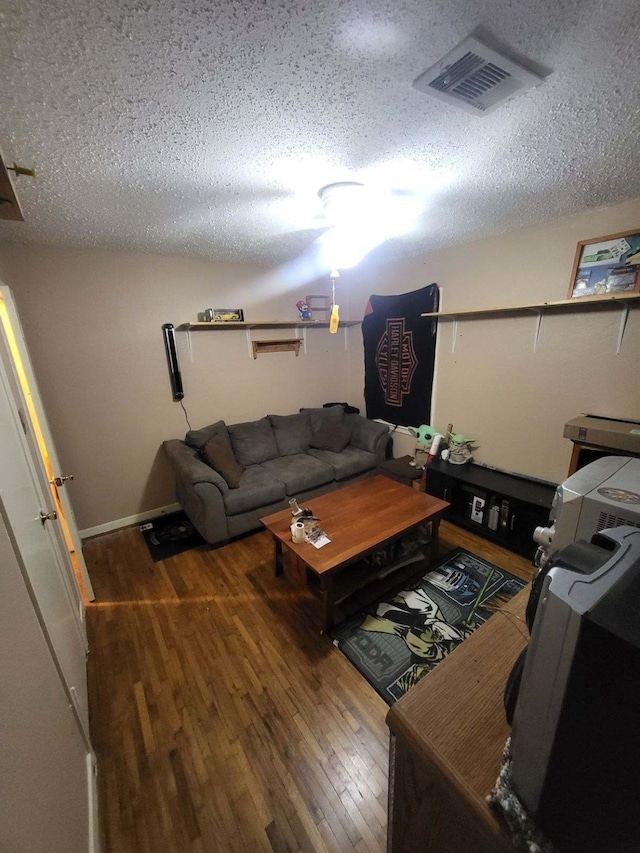 living room with dark hardwood / wood-style flooring and a textured ceiling