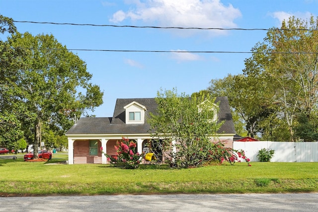 cape cod home with a front lawn