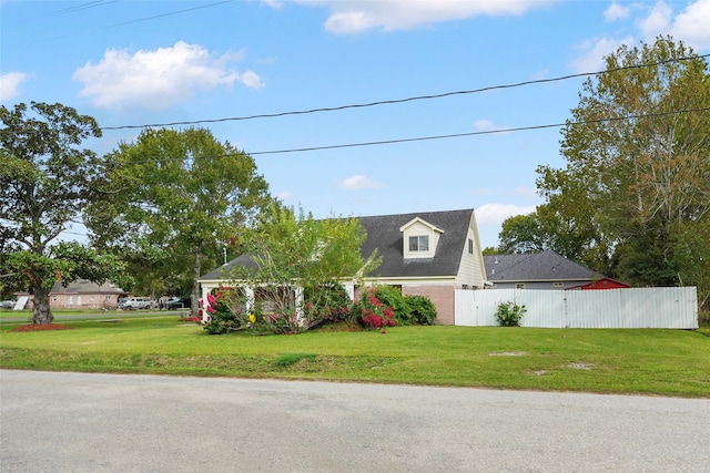 cape cod home featuring a front lawn