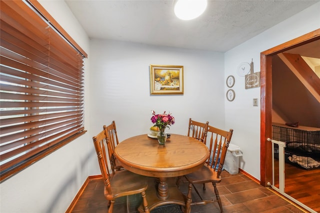 dining space with dark wood-type flooring and a textured ceiling