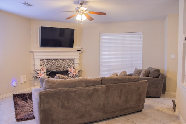 living room featuring light tile patterned flooring, ceiling fan, and a tile fireplace