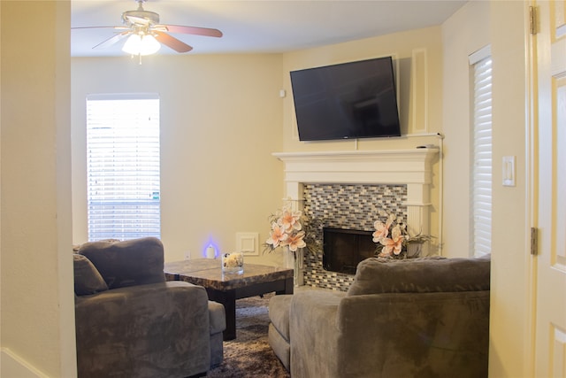 living room featuring a fireplace and ceiling fan